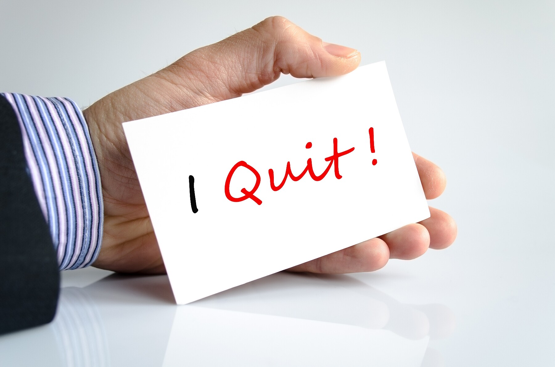 Man holding write card with I QUIT written on it