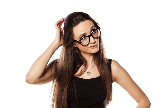 Woman in glasses scratching her head
