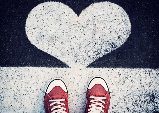 Red tennis shoes pointing at heart sign