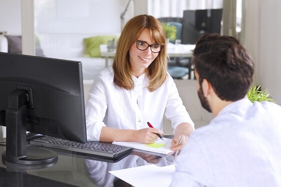 Woman helping man at computer