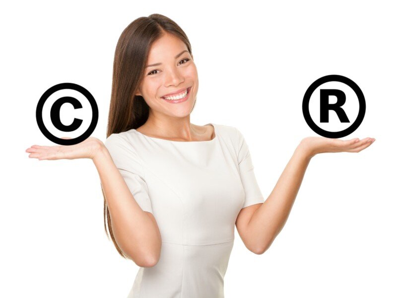 Woman balancing copyright and trademark symbols