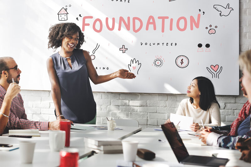 Foundation Sign Behind Business Woman Speaking