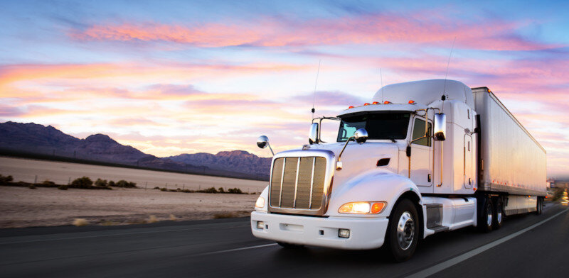 Truck and highway at sunset - transportation background