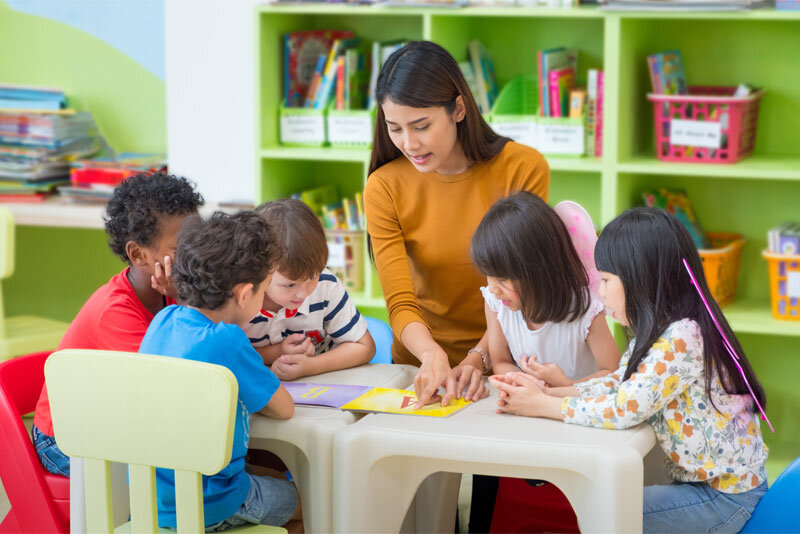 Daycare Teacher Reading to Children