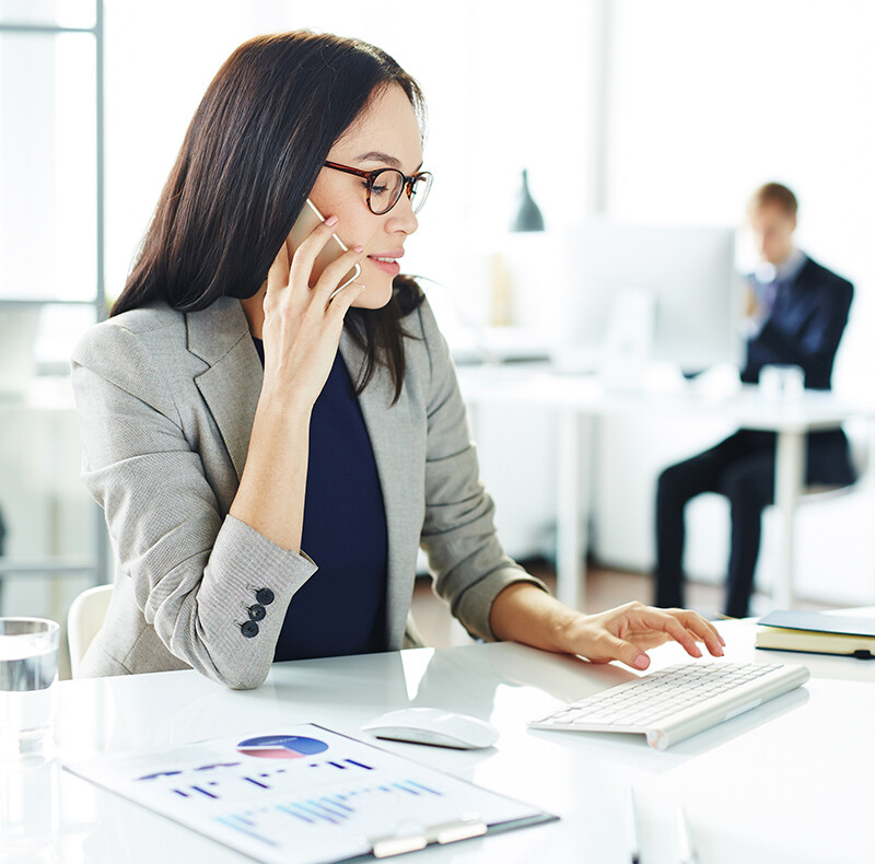 Woman Talking on Cell Phone at Desk