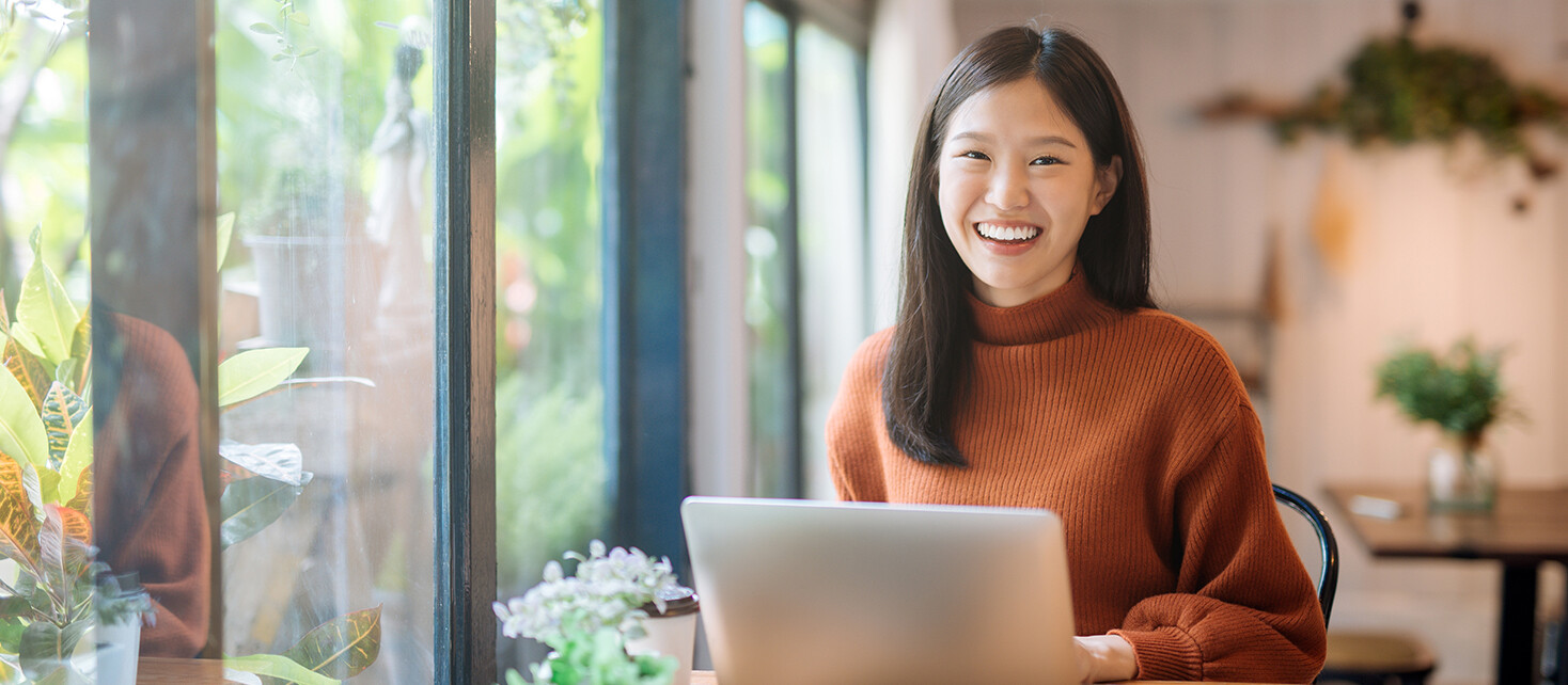 Woman in Sweater Working on Laptop